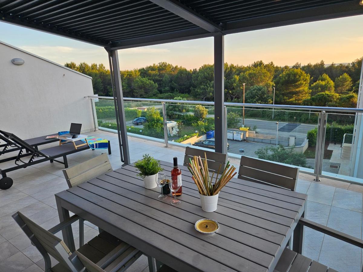 Outdoor terrace with drinks on a wooden table at Diamond Seaview Penthouse